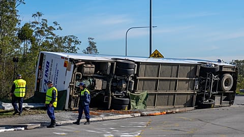 Police inspect underside of bus that rolled in Hunter Valley, Australia