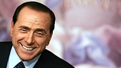 Silvio Berlusconi smiling during a news conference in Rome in 2006, during his second term in office as Prime Minister.