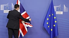 Ein Mitglied des Protokolls richtet die Flagge der EU und der Union vor dem EU-Hauptquartier in Brüssel aus, 21. Februar 2022.