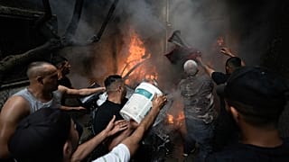 فلسطينيون يخمدون النيران بعد مداهمة الجيش الإسرائيلي مخيم بلاطة للاجئين في شمال الضفة الغربية المحتلة.