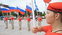 Wide shot members of a Russian patriotic youth movement holding national flags