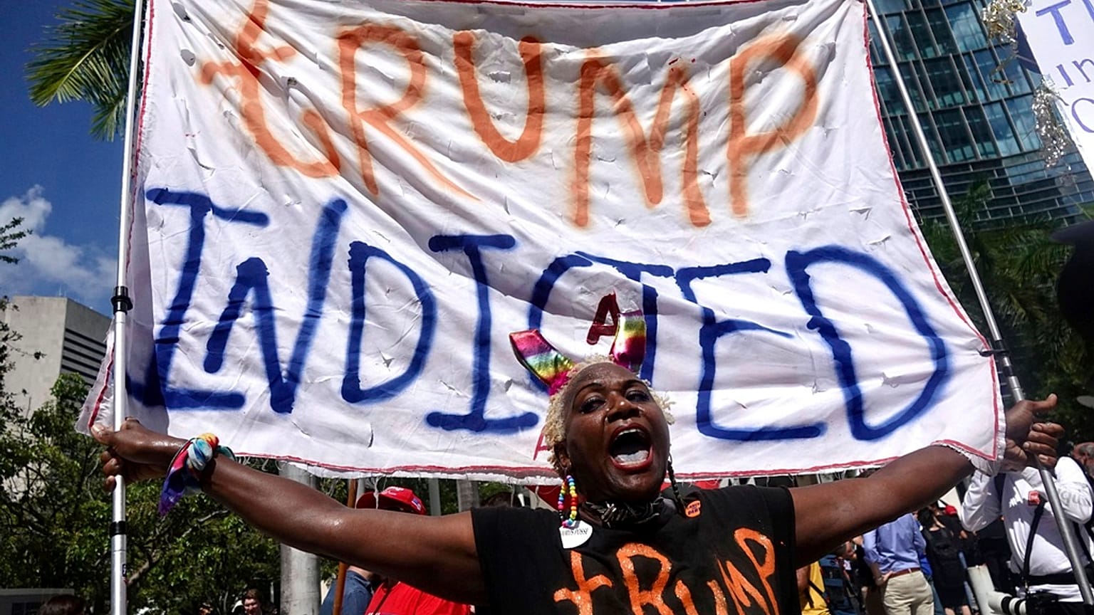 Nadine Seiler holds a banner sign saying "Trump indicted" outside the Wilkie D. Ferguson Jr. U.S. Courthouse on Tuesday, June 13, 2023