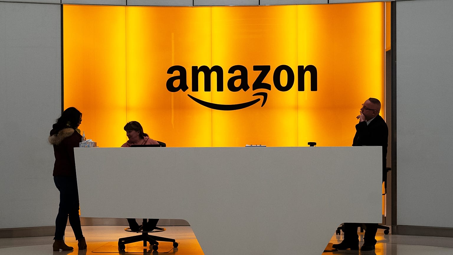 FILE - In this 14 February 2019 photo, people stand in the lobby for Amazon offices in New York.