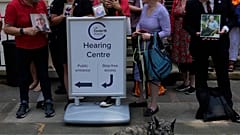 Members of Covid Bereaved Families for Justice hold up their loved ones pictures as they demonstrate outside the UK Covid-19 Inquiry at Dorland House.