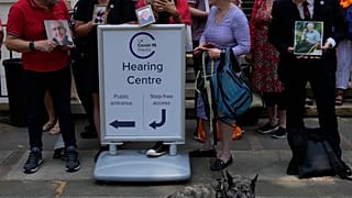 Members of Covid Bereaved Families for Justice hold up their loved ones pictures as they demonstrate outside the UK Covid-19 Inquiry at Dorland House.
