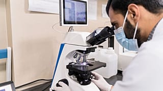 Image shows a stock photo of a lab technician. Researchers at Imperial College London have developed a breath test to detect cancer in its early stages.
