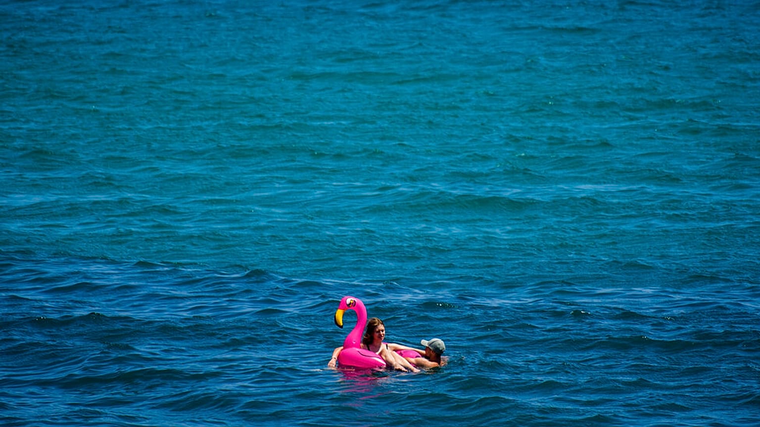 A couple sunbathe in the sea in Barcelona, Spain, Friday, July 9, 2021. 