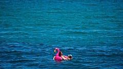 A couple sunbathe in the sea in Barcelona, Spain, Friday, July 9, 2021. 