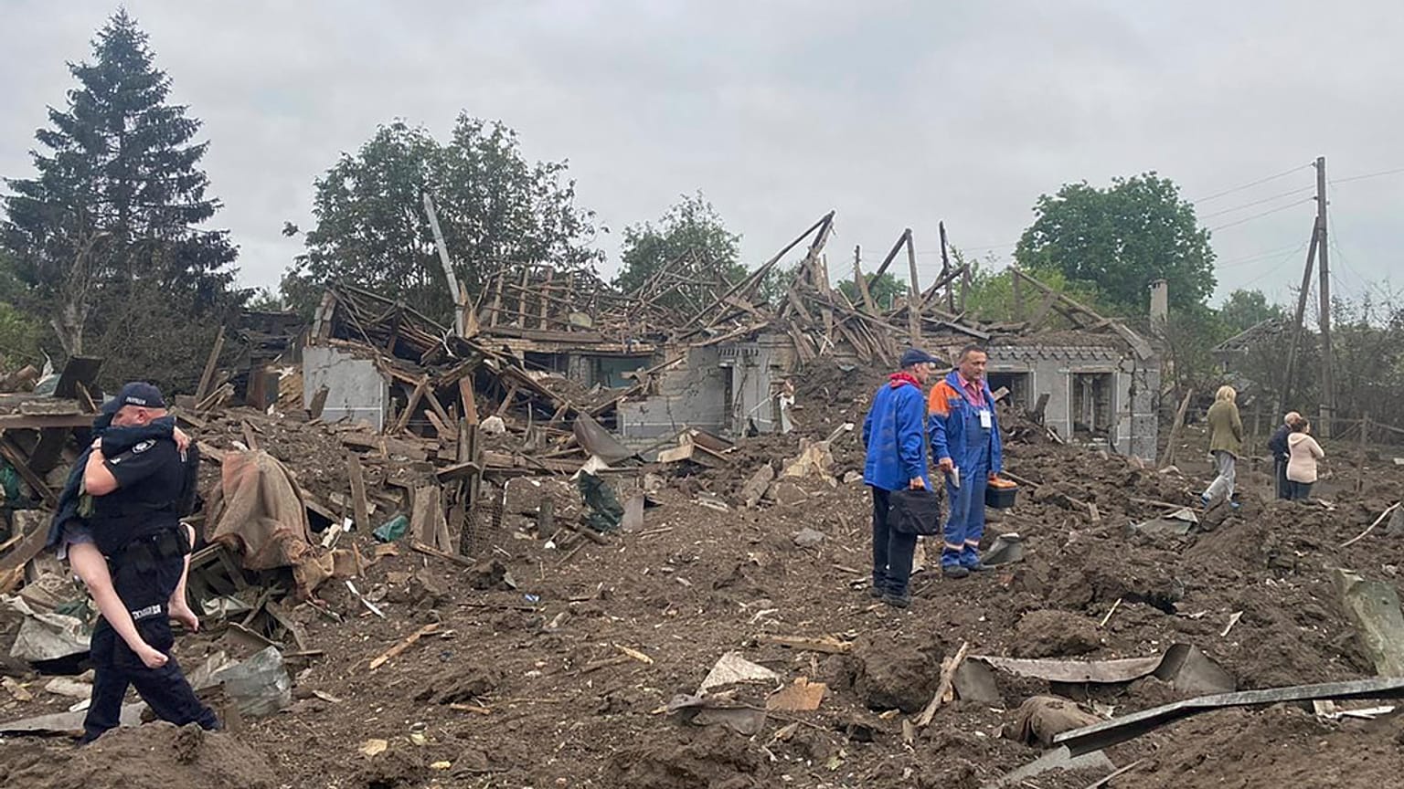 A Ukrainian police officer carries a wounded victim of the deadly morning Russian rocket attack amid debris of the ruined private houses in Kramatorsk,Ukraine, 14 June 2023