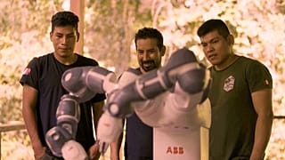 Image shows conservationists from non-profit, Junglekeepers International, overseeing the work of a seed-planting robot that is boosting reforestation efforts in the Amazon.