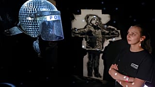 An event marshal surveys some of Banksy's work at the soon-to-open show