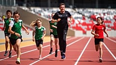A WA elnöke, Sebastian Coe (középen) gyerekekkel fut a budapesti atlétikai világbajnokság futópályáján a Nemzeti Atlétikai Központban 2023.06.15-én. 