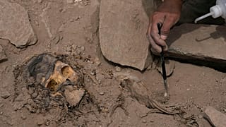 An archaeologist excavates a pre-Hispanic mummy that was discovered next to a training field in the El Rimac neighborhood of Lima, Peru, Thursday, June 15, 2023.