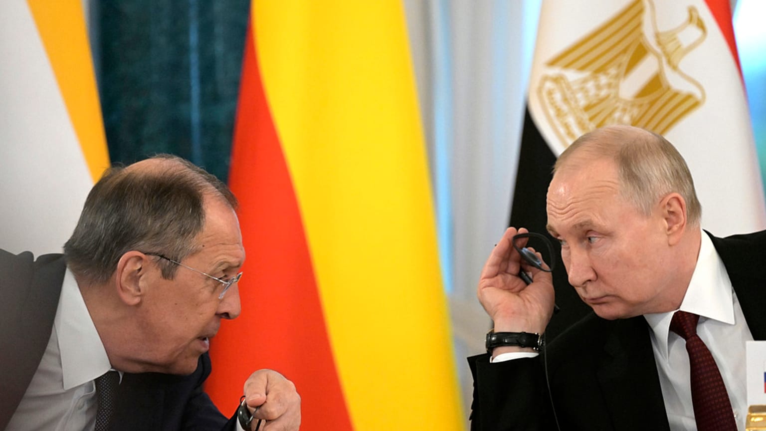 Vladimir Putin and Russian Foreign Minister Sergey Lavrov talk during a meeting with a delegation of African leaders and senior officials in St Petersburg