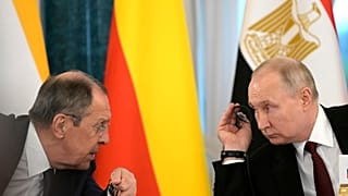 Vladimir Putin and Russian Foreign Minister Sergey Lavrov talk during a meeting with a delegation of African leaders and senior officials in St Petersburg