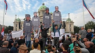 Göstericiler, Sırp Cumhurbaşkanı, İçişleri Bakanı ve Belgrad Belediye başkanını hapishane üniforması ile gösteren kartonlar taşıdı