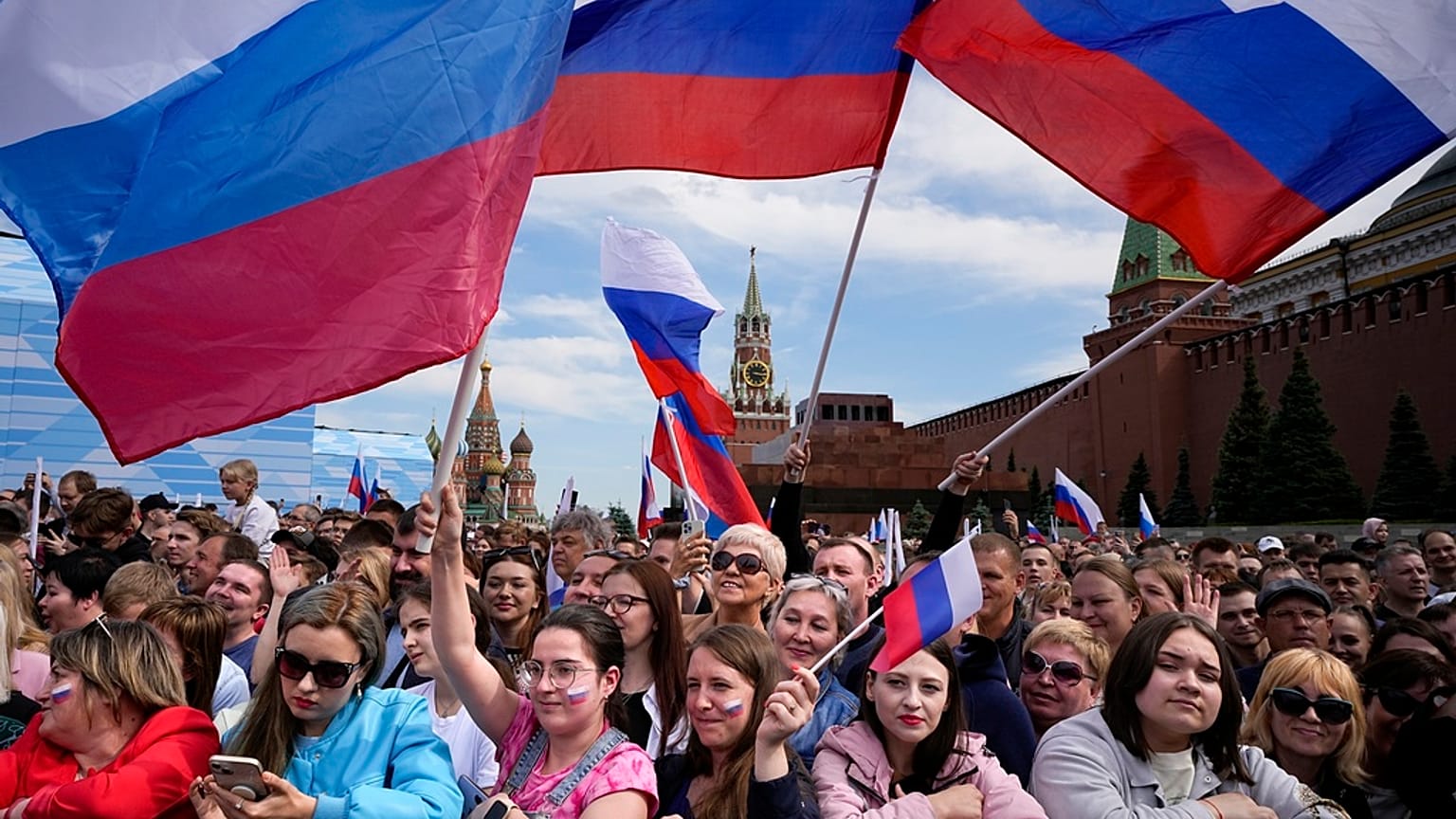 Thousands of people wave Russian national flags as they gather on Red Square to watch a concert dedicated to the Day of Russia in Moscow, Russia, Sunday, June 11, 2023.