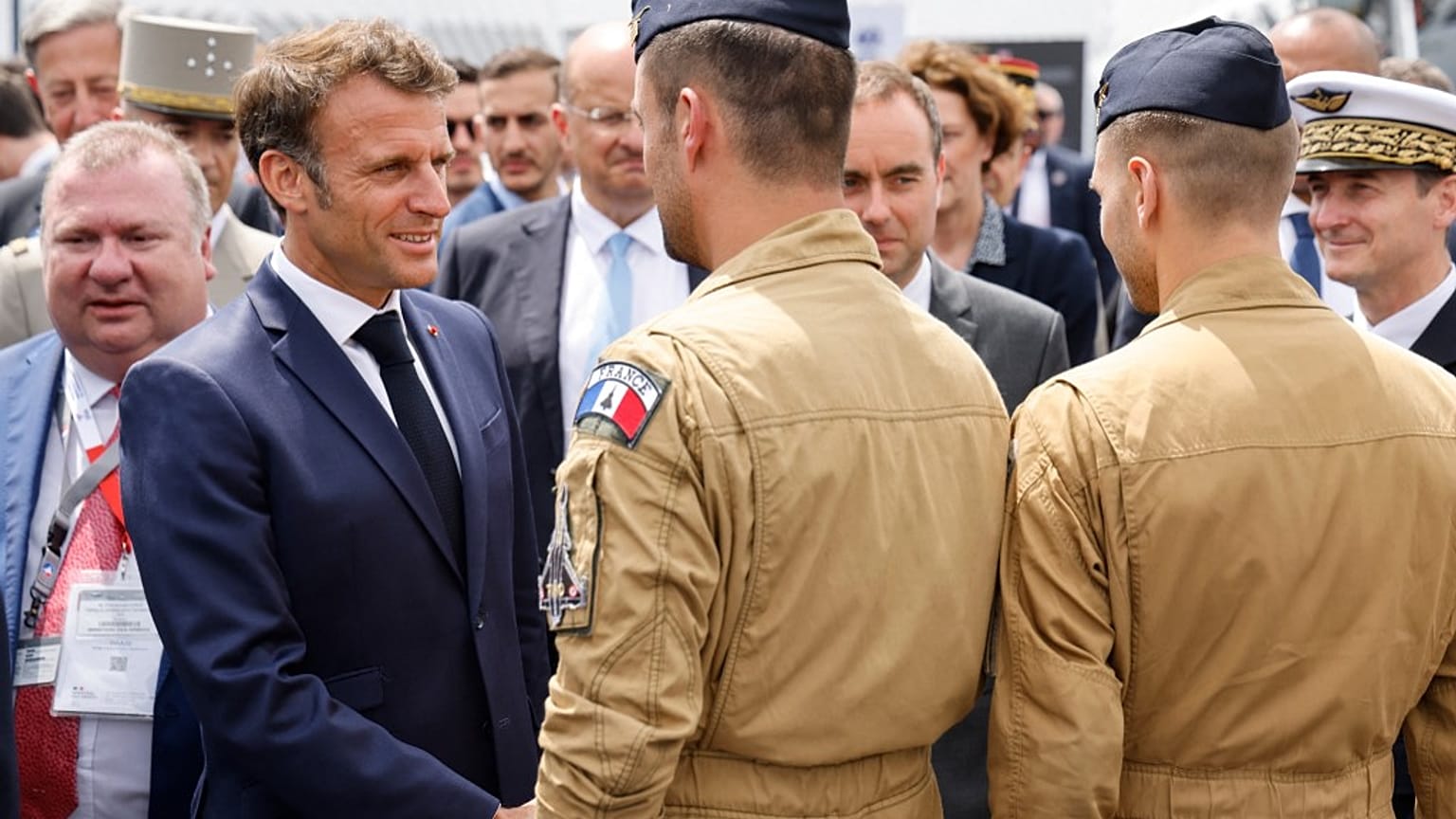 France's President Emmanuel Macron (L) greets Rafale pilots as he visits in the International Paris Air Show at the Paris–Le Bourget Airport on June 19, 2023.