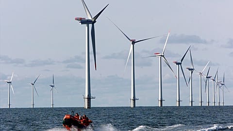 A speed boat passes by offshore windmills in the North Sea offshore from the village of Blavandshuk near Esbjerg, Denmark in this file photo