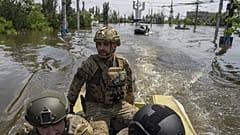 Ukrainian servicemen ride on a speedboat in a flooded neighborhood in Kherson, Ukraine, June 8, 2023.