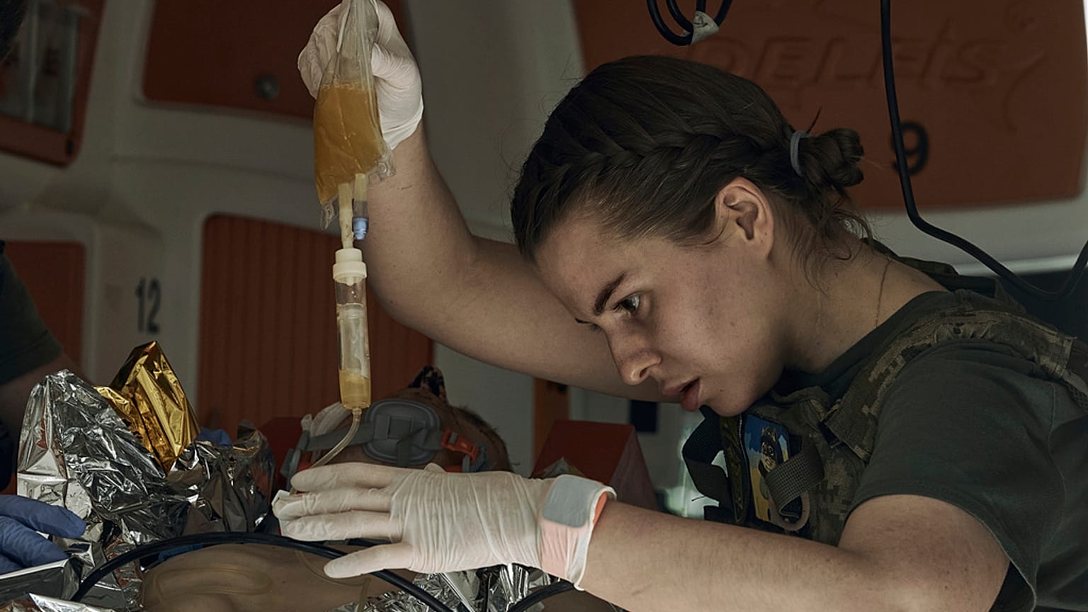 $ukrainische Militärärztin versorgt einen verletzten Soldaten an der Front bei Bachmut