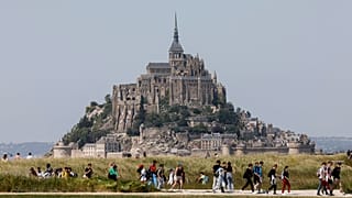 People walk around the Le Mont-Saint-Michel, north-western France, Monday, June 5, 2023. 