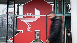 Ein Mann geht am 9. Februar 2022 in Berlin an einem Apothekenlogo vorbei.
