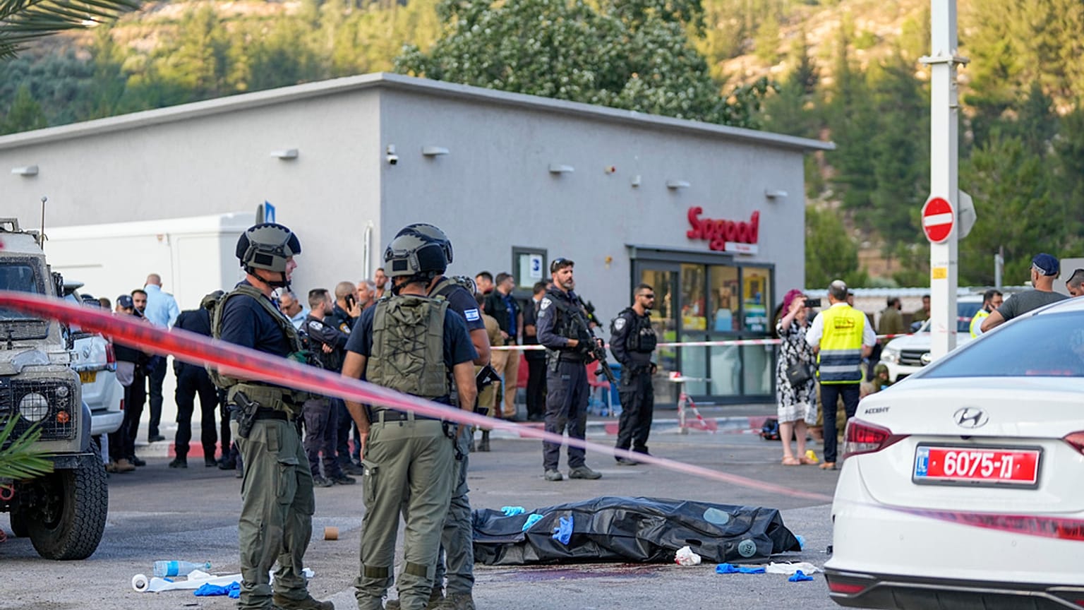 Soldados israelíes junto al cuerpo de uno de los asaltantes palestinos tras el ataque en una gasolinera