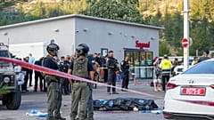 Soldados israelíes junto al cuerpo de uno de los asaltantes palestinos tras el ataque en una gasolinera