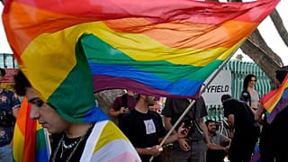 Demonstrators holds rainbow flags during a protest outside from the Parliament house in capital Nicosia, Cyprus, on Thursday, May 25, 2023. 