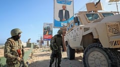 جنود (ATMIS) يقفون بجانب عربتهم المدرعة في أحد شوارع مقديشو