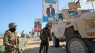 جنود (ATMIS) يقفون بجانب عربتهم المدرعة في أحد شوارع مقديشو