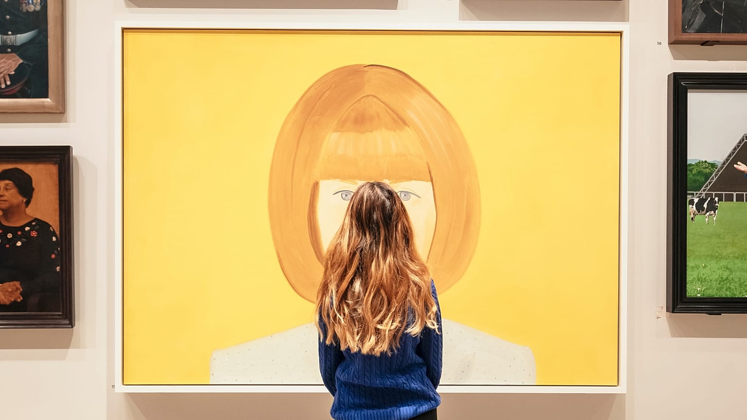 A woman stands in front of the National Portrait Gallery Collection