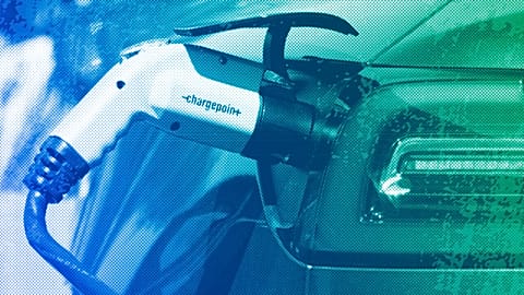 An electric car is charged at a charging station in a parking lot, May 2023