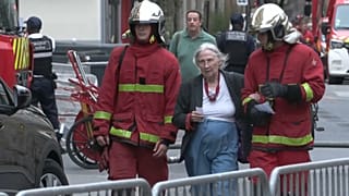 Feuerwehrleute betreuen eine Frau