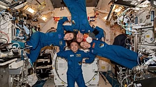 Clockwise from left, Expedition 68 Flight Engineers Anna Kikina of Roscosmos, Josh Cassada and Nicole Mann from NASA, and Koichi Wakata of JAZA gather inside the ISS.