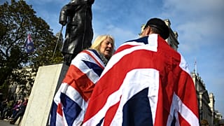 Brit zászlóba burkolózó emberek