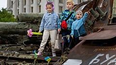 Kinder auf einem ausgebrannten russischen Panzer in Kiew, Ukraine, 11. Juni 2023.