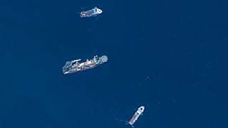 In this satellite image provided by Maxar Technologies, from top to bottom, the vessels Horizon Arctic, Deep Energy and Skandi Vinland search for the missing submersible Titan