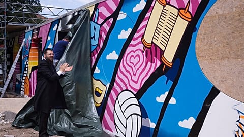 Rabbi Yehuda Teichtal attends the unveiling of a graffiti wall at the entrance of the new Jewish educational and cultural complex.