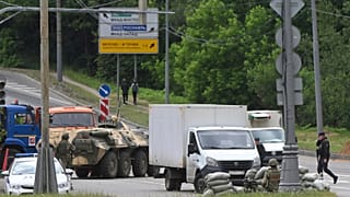 Russian army servicemen, and police officers guard the highway at the entrance to Moscow, Russia, Saturday, June 24, 2023.