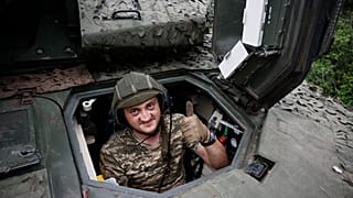 A Ukrainian soldier gives the thumb-up sign on a Swedish CV90 infantry fighting vehicle at his positions near Bakhmut.