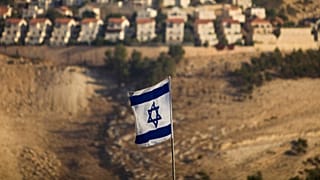 Eine israelische Flagge mit der israelischen Siedlung von Maaleh Adumim im Hintergrund