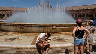 A man cools himself at a fountain in Seville, Spain, April 27, 2023. 
