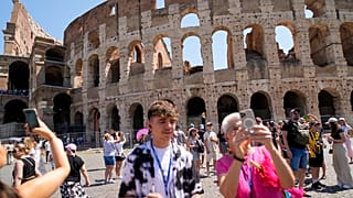 Des visiteurs prennent des photos de l'ancien Colisée à Rome.