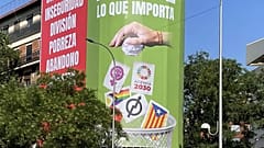 A far-right Vox party sign hangs in Madrid showing a hand dropping cards with symbols representing feminism and the LGBTQ+ community