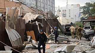 In this photo provided by the National Police of Ukraine, a police officer and a rescue worker walk through Kramatorsk after a Russian attack on 27 June, 2023