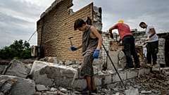 Danyk Rak, 12, clears rubbish on the second floor of Zhanna and Serhiy Dynaeva's house which was destroyed by Russian bombardment in Novoselivka village Aug. 13, 2022