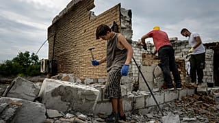 Danyk Rak, 12, clears rubbish on the second floor of Zhanna and Serhiy Dynaeva's house which was destroyed by Russian bombardment in Novoselivka village Aug. 13, 2022