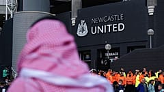 A man with a Saudi Arabian headdress pases by St. James' Park in Newcastle. 